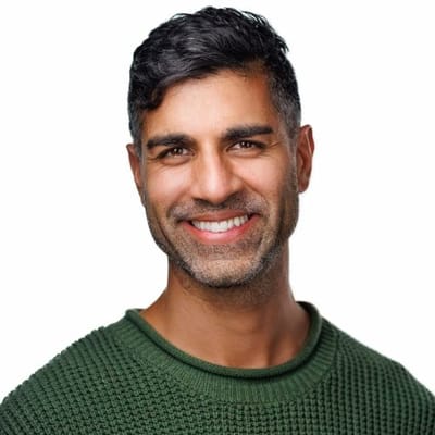 Khurram Naik smiling in a green sweater